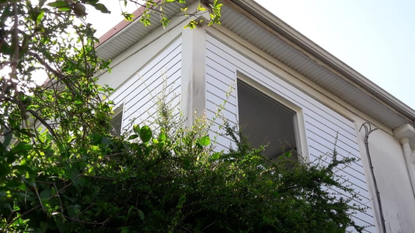 Bardage aluminium à clins gris sur la façade d'une maison