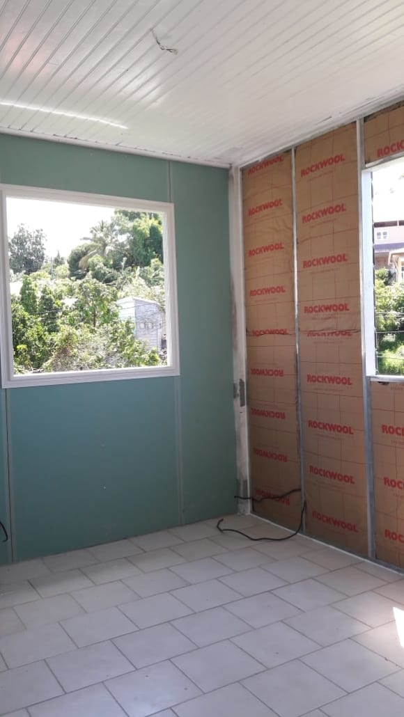 Pose d'un bardage aluminium sur ossature en cours de chantier en Martinique