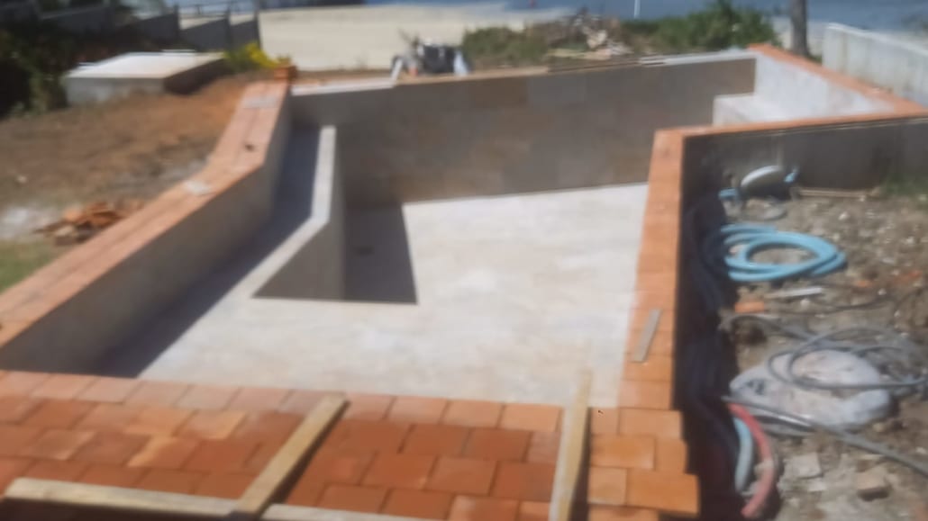 Piscine béton sur mesure avec plage carrelée dans un jardin en Martinique